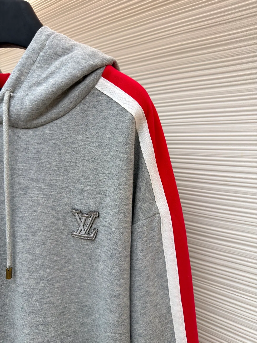 LOUIS VUITTON SKI ski series color-blocked hooded sweatshirt ●Original version: purchased and developed by 14180 ●Item number: 1681688-A95 ●Fabric: cotton fabric ●Technology: embroidery production ●Color: red, white and gray ●Version: fitted version ●Weight: about 725 grams ●Size: S-M-L-XL ●Description: This hooded sweatshirt is made of high-density cotton blend fabric and has been pre-shrunk to ensure it is not easily deformed after wearing. The main body of the shirt is gray, and the sleeves are spliced ​​with red and white webbing to create a sharp contrast. The LV logo on the chest adopts three-dimensional embroidery technology, with fine stitching and strong three-dimensional effect. The letter patterns on the sleeves also use embroidery technology, with smooth lines and rich layering. The hooded design is equipped with a drawstring with metal decoration at the end, which is both beautiful and practical. There are kangaroo pockets on both sides of the body for easy placement of small items. The cuffs and hem are ribbed to increase wearing comfort while effectively preventing wind. The overall cut is loose and suitable for a variety of body types. All sutures are made of high-strength polyester threads, which have been tested many times to ensure that they will not open during long-term wear. The overall wiring is straight and delicate, the fabric is comfortable and soft, and the color is consistent without color difference. It can be matched with the same style to create a fashionable look and control various occasions. Customized accessories, complete with three standards, same style for men and women!